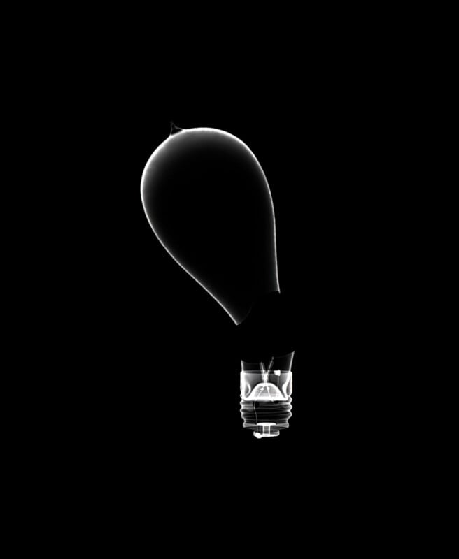 An X-ray image of a broken light bulb with the glass bent and distorted, showing the internal filament and base on a black background.