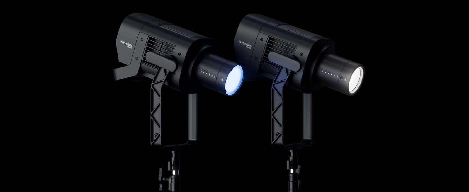 Two black professional studio lights on stands, one emitting a blue light and the other a white light, set against a black background.