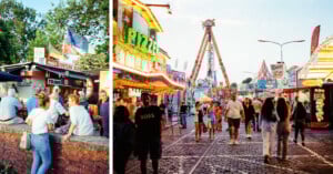 People enjoy snacks at a food stand on the left, while a lively, colorful fair with rides and bright lights is bustling with visitors on the right. The scene is vibrant and festive, with many people walking around.