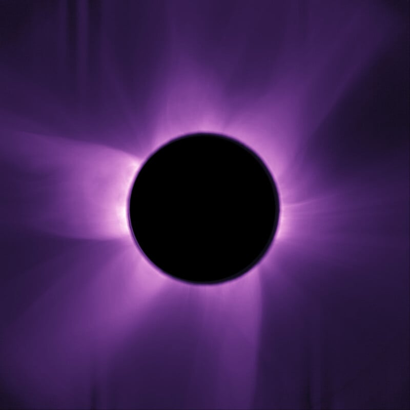 A dark circle representing the moon completely covers the sun, with vivid purple and violet solar corona flares radiating outwards against a black background during a solar eclipse.