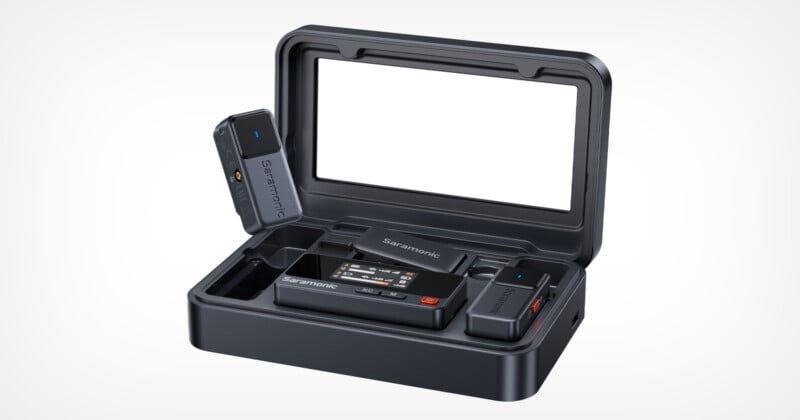 A portable Saramonic wireless microphone system in a black charging case, including a transmitter, receiver, and microphone components, with the case lid open and an empty display area inside the lid.