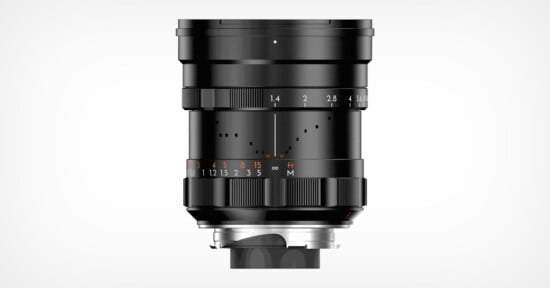 A black camera lens with manual focus and aperture rings, featuring white and orange markings for measurements, shown against a plain white background.