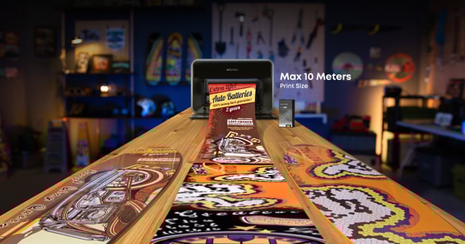 A printer creates vibrant, detailed, custom designs on long wooden boards in a colorful workshop, with a display indicating a maximum print size of 10 meters.