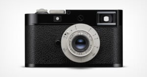 A black and silver vintage-style camera with a textured grip, a round lens in the center, and a viewfinder on the top right side against a plain white background.
