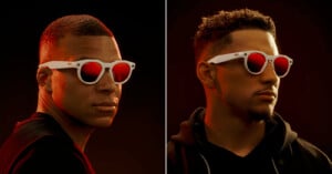 Two men wearing white-framed sunglasses with red lenses, facing slightly sideways against a dark background with red lighting on their faces.