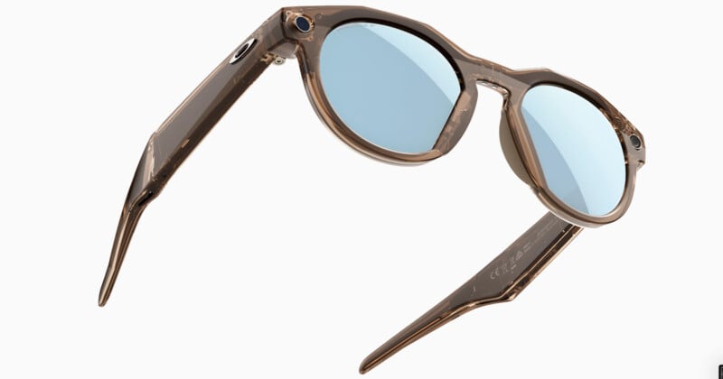 Transparent brown sunglasses with round blue-tinted lenses and thick arms, viewed at an angle on a white background.