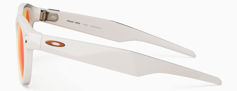 Side view of white sunglasses with orange-tinted lenses, featuring an Oakley logo on the arm and the words “CHARLEY MX974” and “CE” printed inside the arm.