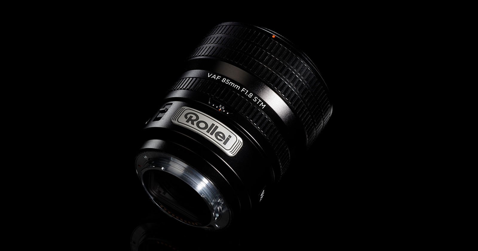 A Rollei VAF 85mm F1.8 STM camera lens is displayed on a black background, showcasing its textured focus ring and branding in silver lettering.