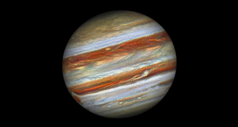 A detailed image of Jupiter shows its swirling bands of brown, orange, and white clouds, with the prominent Great Red Spot visible on the left side against a black background.