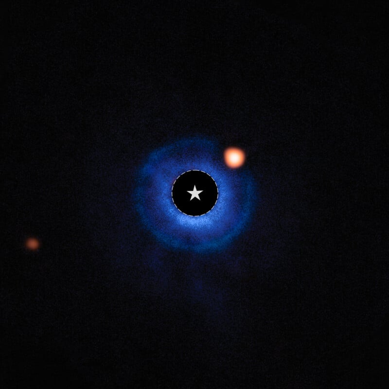 A bright star at the center with a blue halo, surrounded by two glowing orange dots against a black background representing exoplanets orbiting the star.