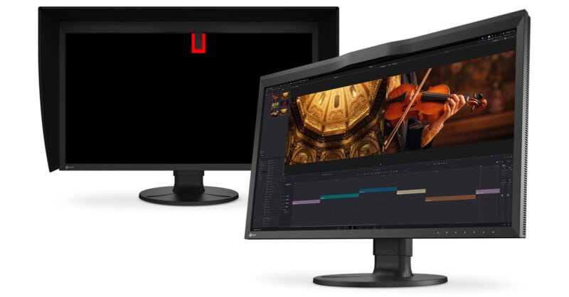 Two black computer monitors with hoods; one shows a violin editing project on the screen, while the other monitor is turned off with a red "U" symbol near the top center.