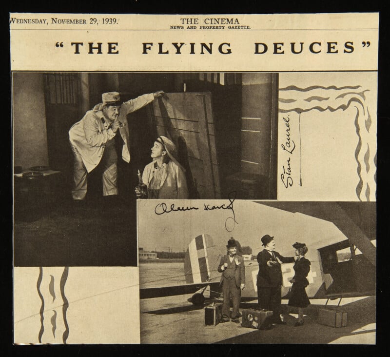 Black-and-white newspaper clipping titled "The Flying Deuces" shows two scenes: one with two men in a room with a large prop, and another of three people standing beside an airplane. Handwritten signatures are visible.