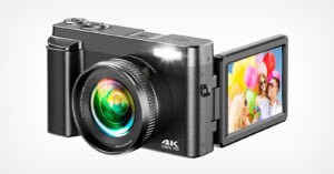 A compact digital camera with a large lens and a flip-out screen displaying a colorful photo of two people with balloons. The camera body is labeled "4K Ultra HD.