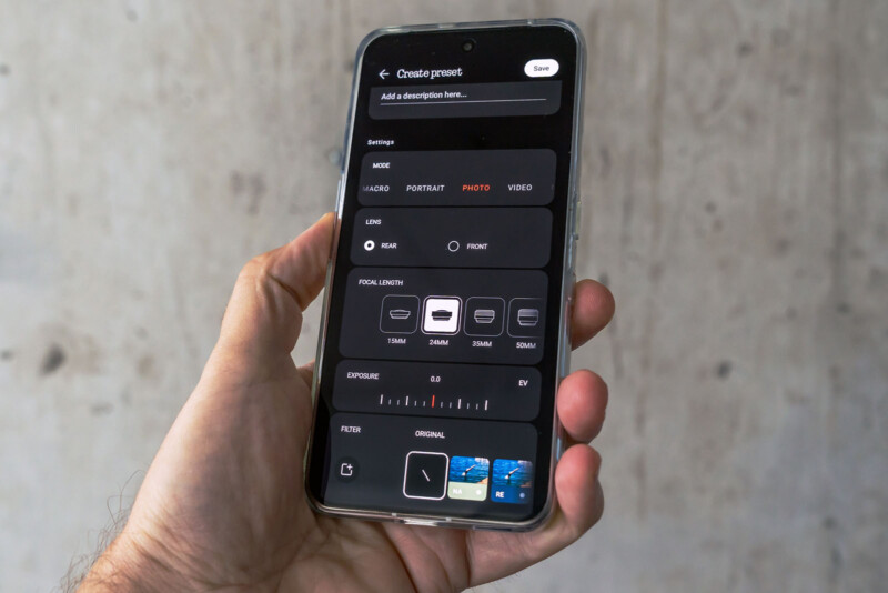 A hand holds a smartphone displaying a camera settings menu, showing options for mode, lens, profile length, exposure, and filters against a plain, light-colored background.