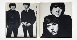 Black-and-white photos of two men on an open album: the left side shows them standing together in suits, and the right side shows close-up portraits of their faces, one resting his chin on the other’s head.