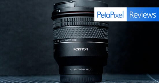 A Rokinon super wide-angle camera lens is displayed upright against a dark background, with the PetaPixel Reviews logo in the top right corner.