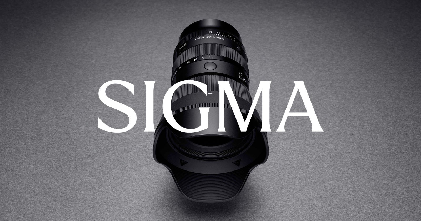 A Sigma camera lens with a lens hood is positioned vertically on a gray surface, with the word "SIGMA" in large white letters overlaid across the image.