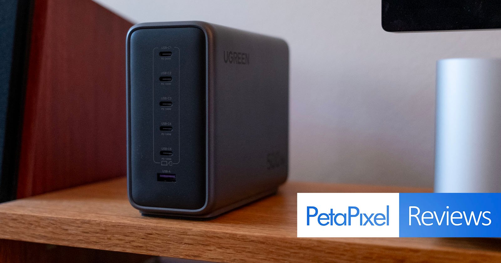 A UGREEN charging station with multiple USB-C and one USB-A port sits on a wooden shelf. The Petapixel Reviews logo appears in the bottom right corner.