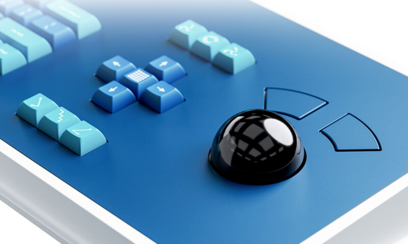 Close-up of a blue control panel featuring a large black trackball, directional arrow buttons, and other various blue keys with symbols, all arranged in a modern and organized layout.