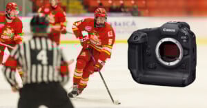 A hockey player in red uniform skates with the puck during a game, with other players and a referee nearby; a Canon EOS R1 camera is superimposed on the right side of the image.