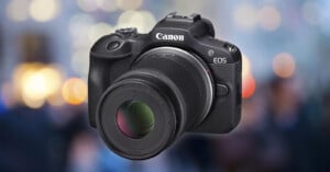 A black Canon EOS digital camera with a large lens is shown against a blurred background with colorful bokeh lights.
