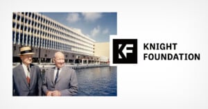 Two men in suits stand by the water in front of a modern office building under a blue sky. To the right is the Knight Foundation logo and text on a white background.