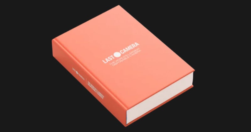 A closed, orange hardcover book titled "LAST CAMERA" with additional small white text on the cover, placed on a black background.