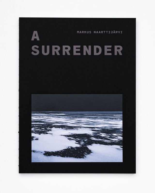 A black book cover titled "A Surrender" by Markus Naarttijärvi, featuring a photograph of a snowy, partially frozen landscape with dark water and ice.