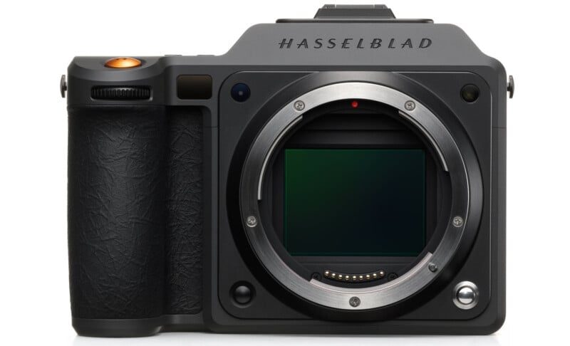 A front view of a Hasselblad digital camera body with no lens attached, showing the large sensor and metal lens mount. The camera has a textured grip and a prominent shutter button.