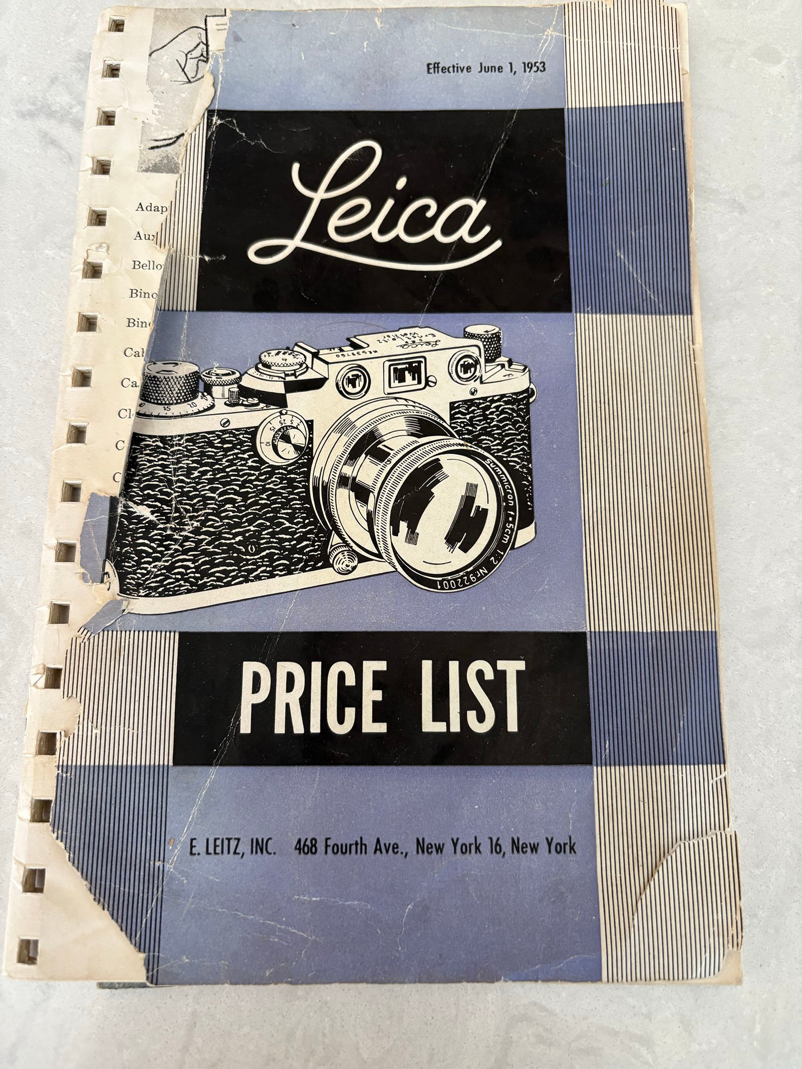 An old, worn price list booklet for Leica cameras, dated June 1, 1953, with a black-and-white illustration of a vintage camera on the cover and the address of E. Leitz, Inc. in New York.