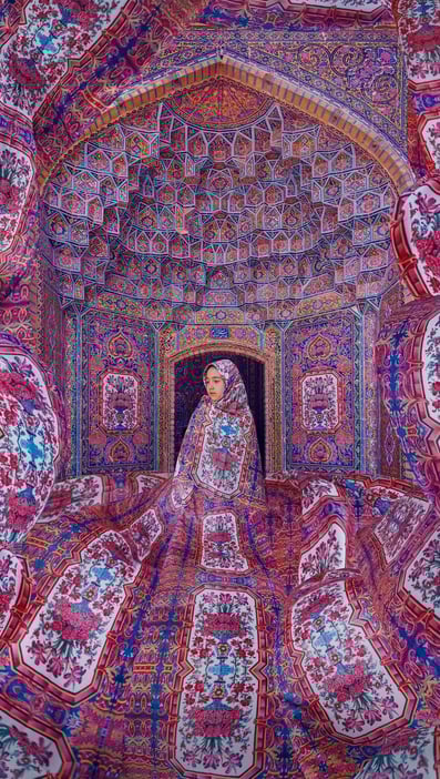 A woman wrapped in a vibrant, floral-patterned fabric stands in an intricately decorated room with colorful, geometric and floral Persian designs covering the walls, ceiling, and floor, blending into the surroundings.