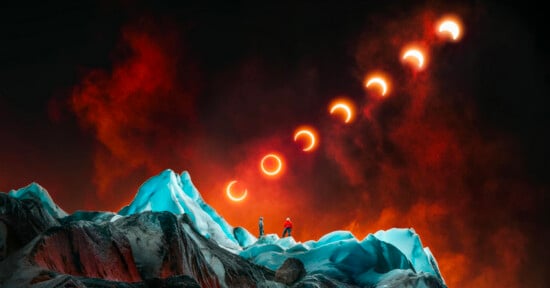 Two people stand on icy, jagged terrain under a dramatic red sky, watching a solar eclipse sequence as the sun and moon create crescent shapes and a glowing ring above them.