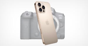 A gold iPhone with three rear cameras is positioned in front of a blurred Canon EOS R5 camera on a white background.