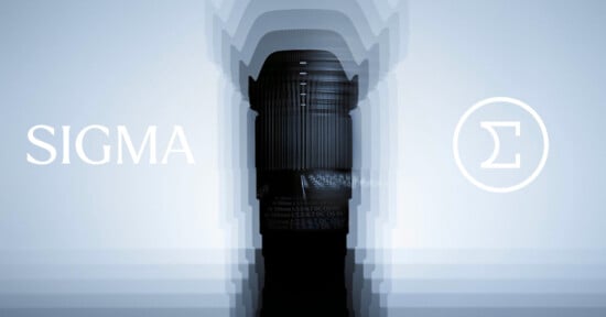 A Sigma camera lens stands upright in the center with a layered blur effect. "SIGMA" is written on the left and the Sigma logo (Greek letter sigma) in a circle appears on the right, all on a light blue background.