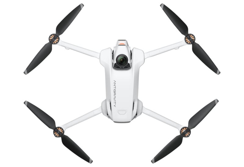 A white quadcopter drone with four black propellers and a camera mounted at the front, displayed against a plain white background in a top-down view.