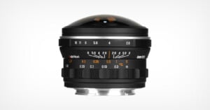A wide-angle camera lens with a dome-shaped front element, focus and aperture rings showing f-stop and distance markings, displayed on a white background.