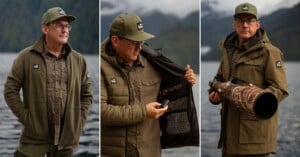 Three images show a man outdoors by a lake, wearing an olive jacket and cap. In the center, he opens his jacket to reveal an electronic panel. On the right, he holds a large camera with a camouflage lens cover.