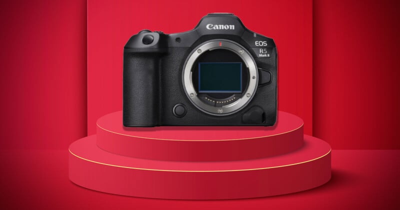 La cámara sin espejo Canon EOS R5 Mark II se muestra en un podio redondo rojo de tres capas con un fondo rojo a juego.