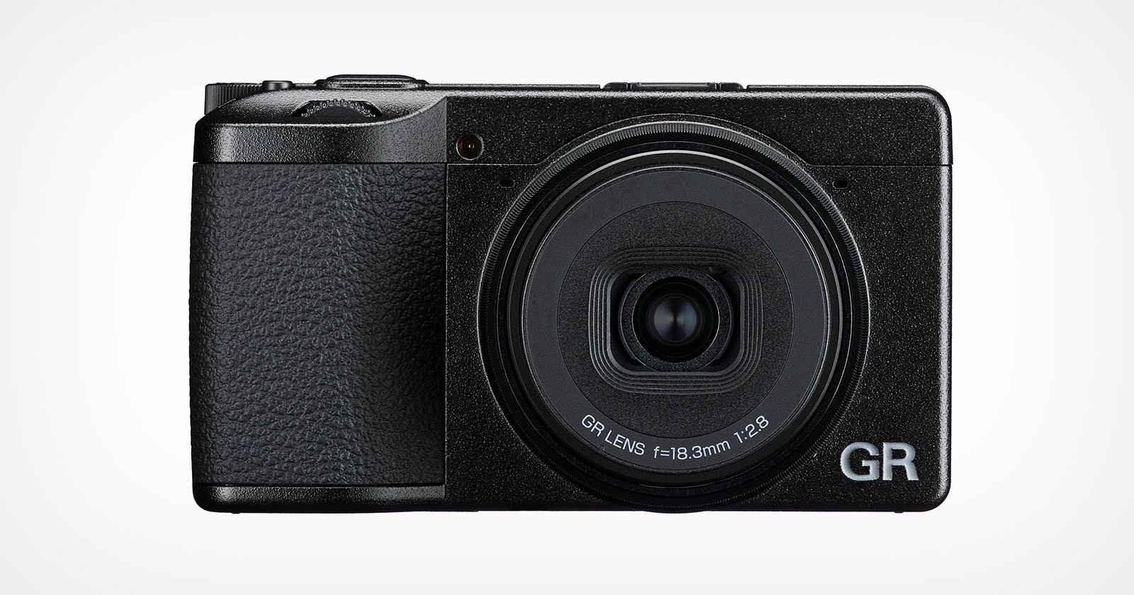 A black compact digital camera with a textured grip, large circular lens labeled "GR LENS f=18.3mm 1:2.8", and the letters "GR" in silver on the bottom right corner of the front.
