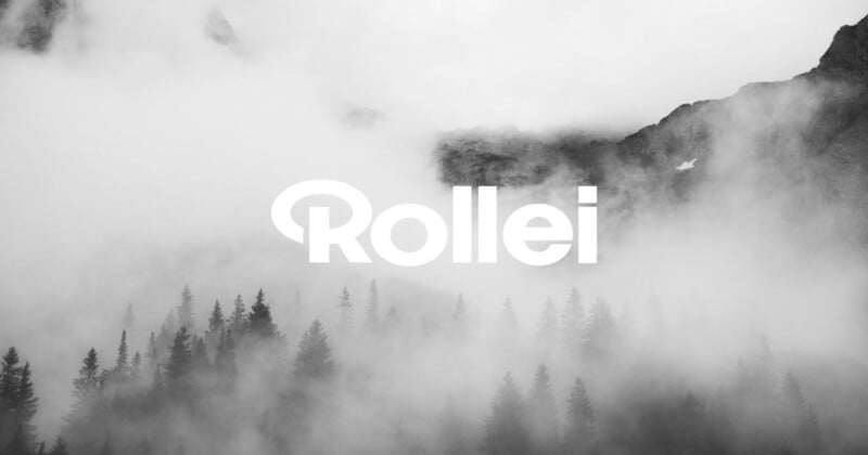 Foggy mountain landscape with dark pine trees in the foreground, rocky peaks in the background, and the word "Rollei" in bold white letters across the center.