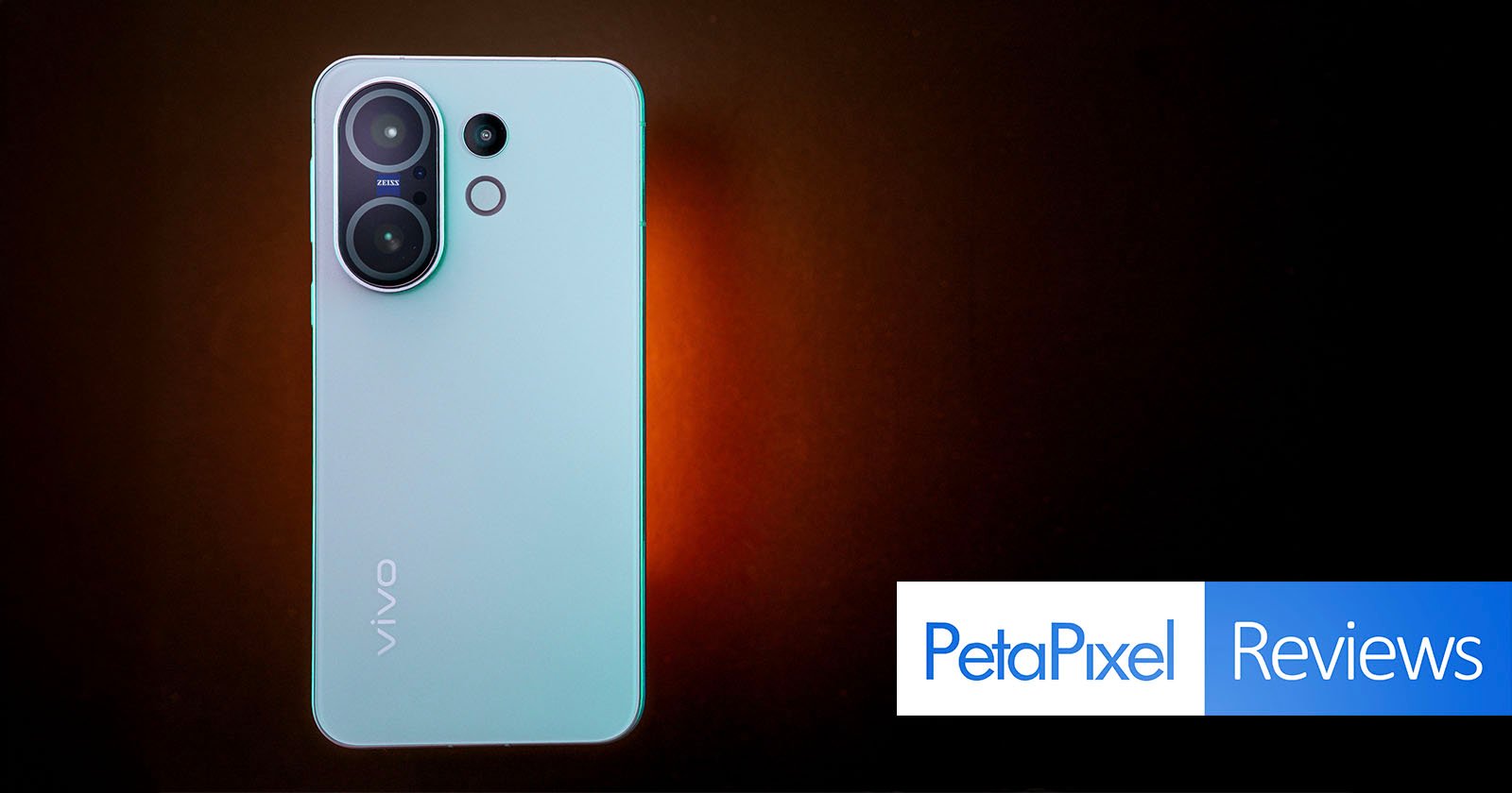 A light blue Vivo smartphone with dual rear cameras is displayed on a dark brown background. The phone is centered above the Petapixel Reviews logo in the bottom right corner.
