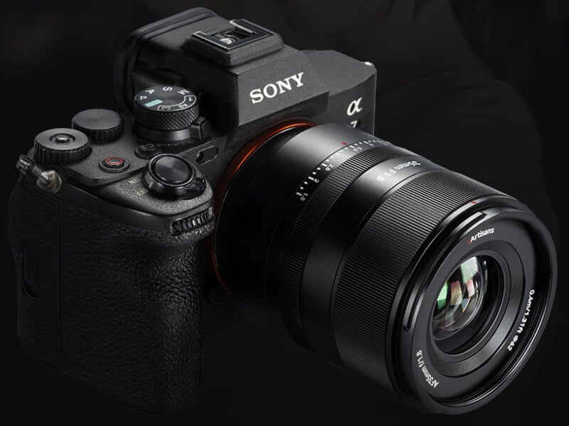 A close-up view of a Sony Alpha mirrorless digital camera with a large interchangeable lens, set against a dark background.