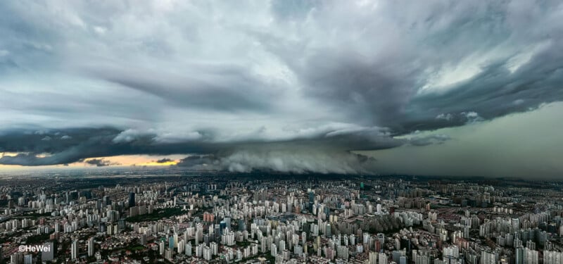 Las dramáticas nubes de tormenta forman un denso paisaje urbano, con la luz del sol rompiendo las nubes a la izquierda, con oscuridad y nubes pesadas que dominan.