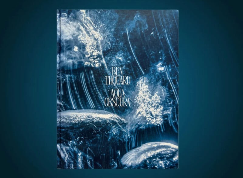 A book titled "Ben Thouard Aqua Obscura" with a cover featuring abstract underwater photography in shades of blue, depicting swirls and bubbles.