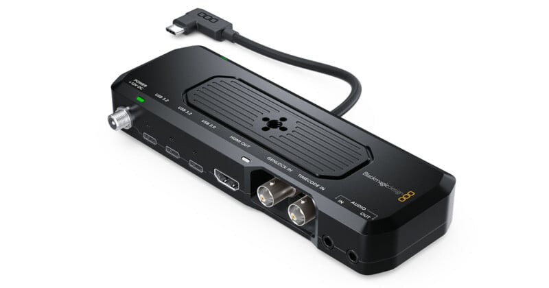 A Blackmagic Design ATEM Streaming Bridge device with various input/output ports and a short attached HDMI or USB cable, displayed on a white background.
