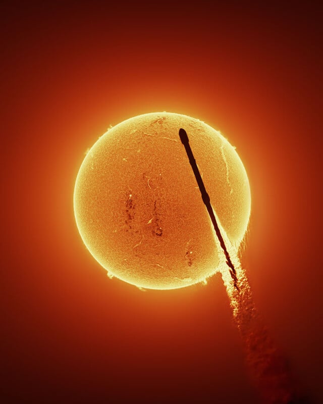 A rocket launches into space, silhouetted against the bright, fiery surface of the Sun, creating a striking contrast and a dramatic trail of exhaust.