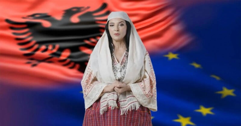 A woman in traditional Albanian clothing stands in front of blended Albanian and European Union flags.