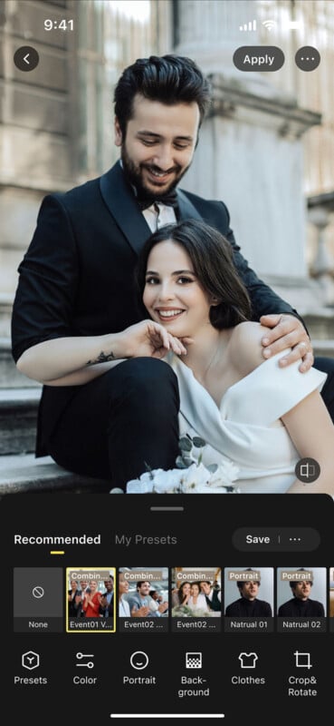 A smiling couple poses on outdoor stone steps; the man in a black suit sits behind a woman in an off-shoulder white dress, resting her chin on her hand. Photo editing app interface and preset options are visible.