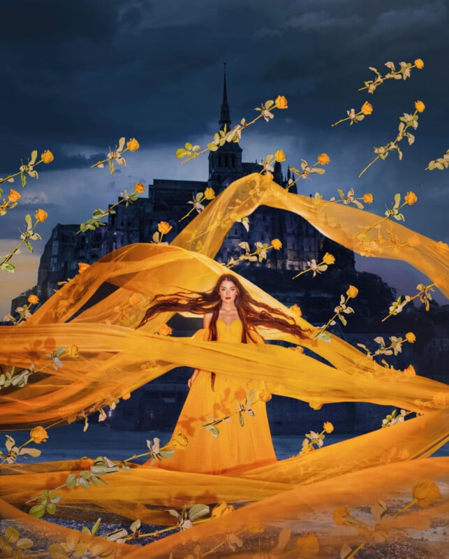 A woman in a long yellow dress stands before a dramatic castle, surrounded by swirling yellow fabric and floating yellow roses, set against a dark, cloudy sky at dusk.