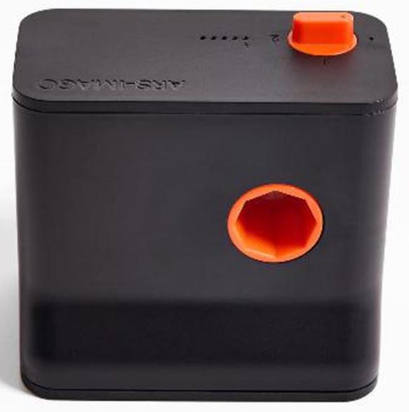 A black and orange electric pencil sharpener with a hexagonal opening and a red/orange knob on top, viewed from an angle.